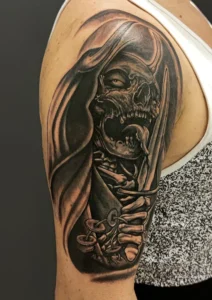 tatuaż męski na ramieniu czaszka ze sztyletem cover up