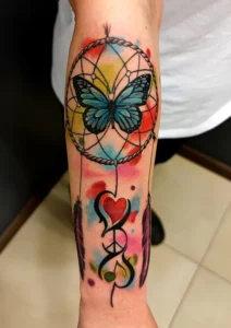 tatuaż na przedramieniu łapacz snów kolorowy motyl serce