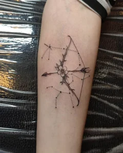 tatuaż na przedramieniu strzelec łuk kwiaty