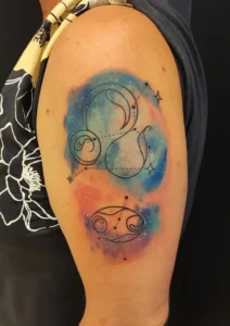 tatuaż na ramieniu kolorowy znak zodiaku