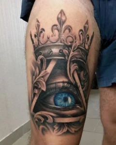tatuaż na udzie oko z koroną